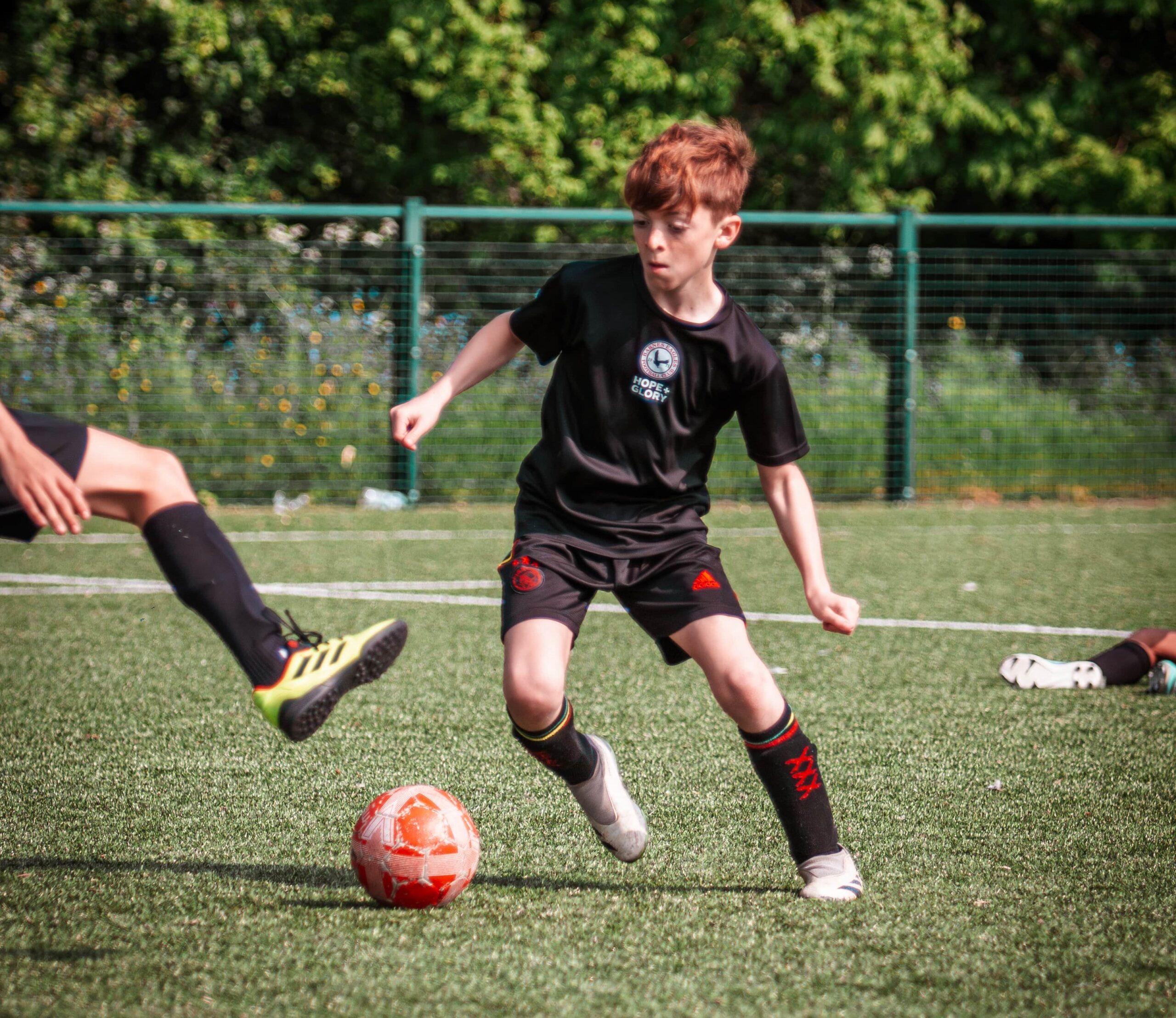 Boy dribbling football